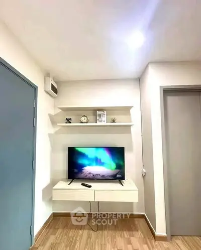 Modern living room with wall-mounted TV and stylish shelves.