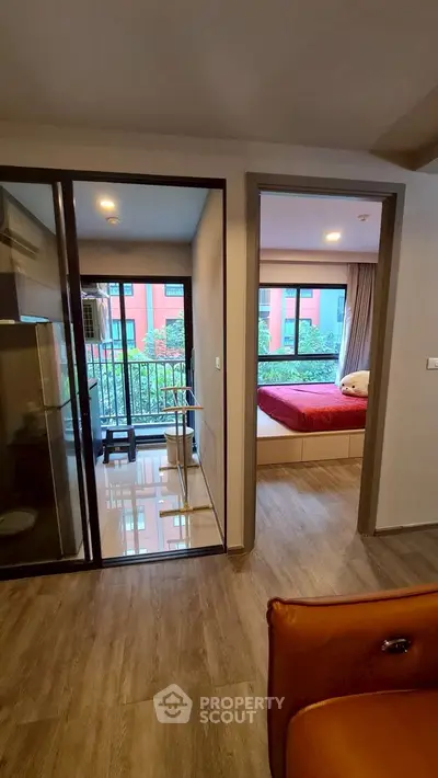 Modern apartment interior with glass partition and cozy bedroom view.
