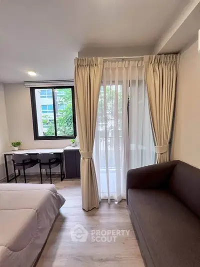 Cozy bedroom with balcony view, featuring modern decor and ample natural light.