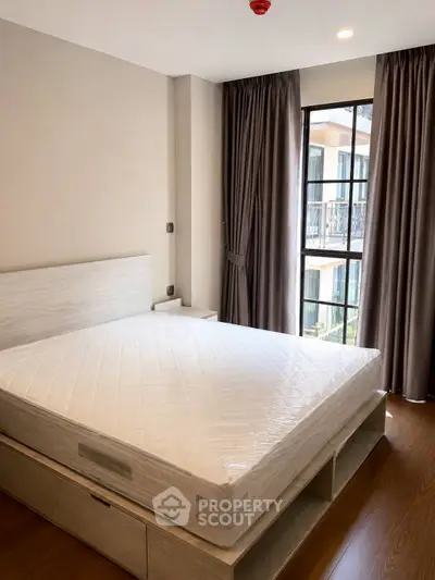 Modern bedroom with large window and elegant curtains in a stylish apartment.