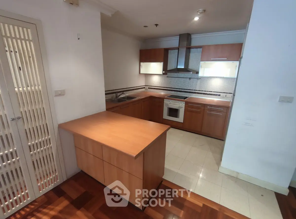 Modern kitchen with wooden cabinetry and sleek appliances in open layout