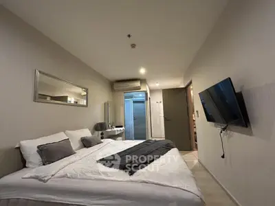 Modern bedroom with wall-mounted TV and cozy bedding in a stylish apartment.
