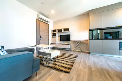 Modern living room with sleek furniture and open kitchen layout in a stylish apartment.