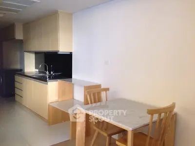 Modern kitchen with sleek cabinetry and dining area in a stylish apartment.