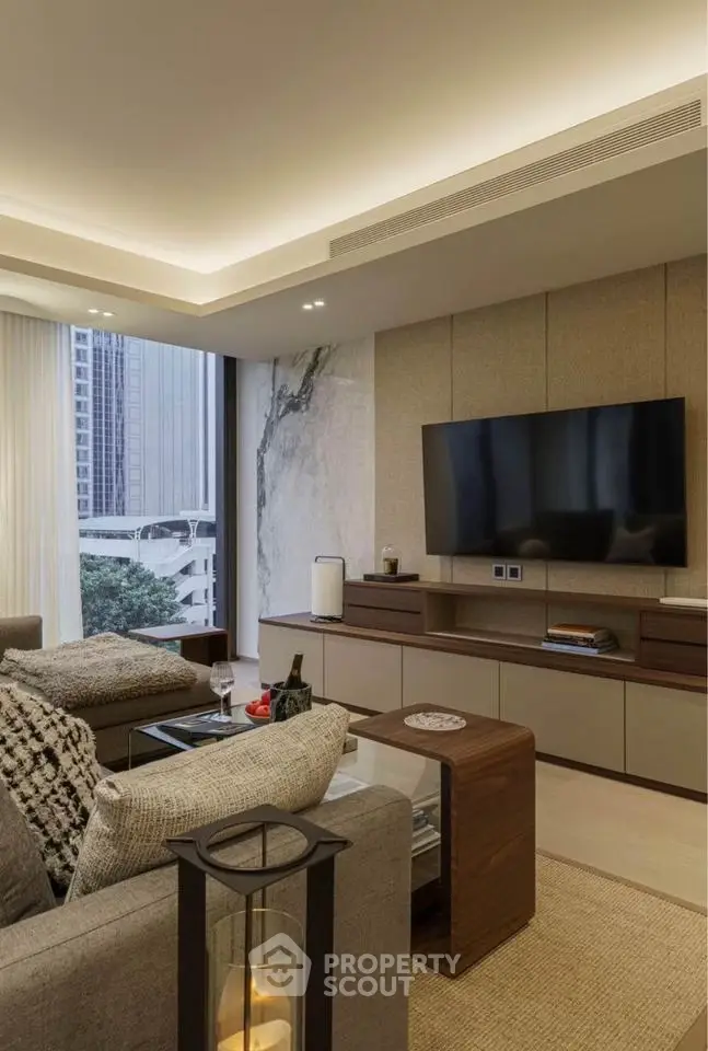 Luxurious modern living room with elegant decor and city view, featuring a large TV and comfortable seating.