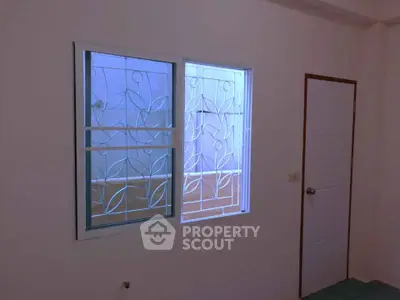 Minimalist room with decorative window grille and simple door