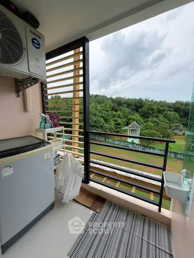 Charming balcony with lush green view and modern appliances, perfect for relaxation and utility.