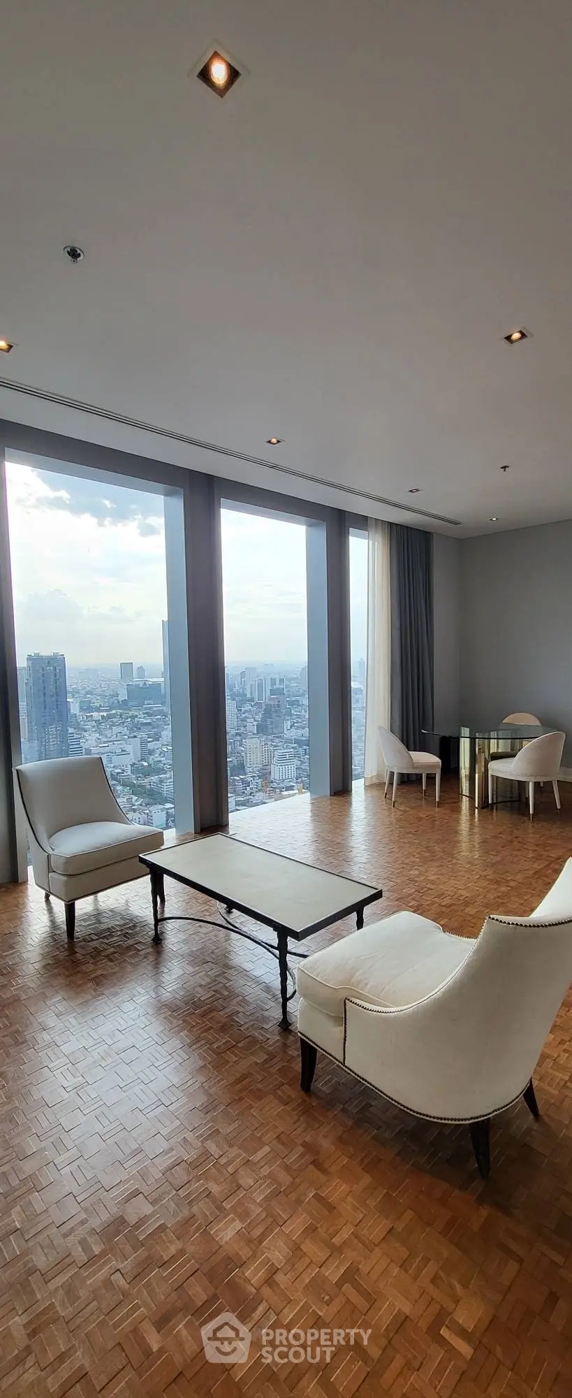 Luxurious high-rise living room with panoramic city views and elegant furnishings.