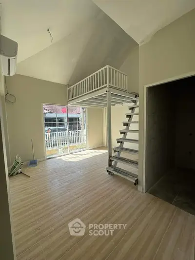 Spacious loft-style living room with high ceilings and large windows for natural light.