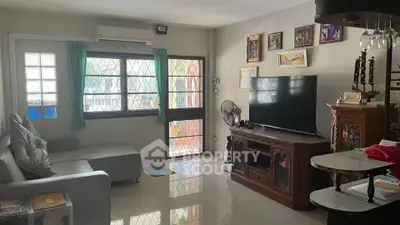 Cozy living room with modern furniture and large TV, perfect for relaxation.