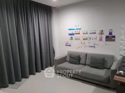 Cozy living room with gray sofa and creative wall art, perfect for family relaxation.