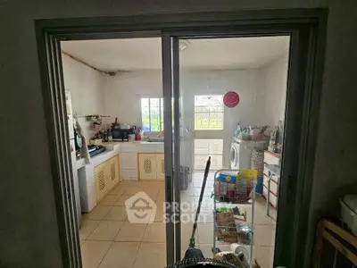 Cozy kitchen with sliding glass doors and laundry area, featuring tiled floors and ample natural light.