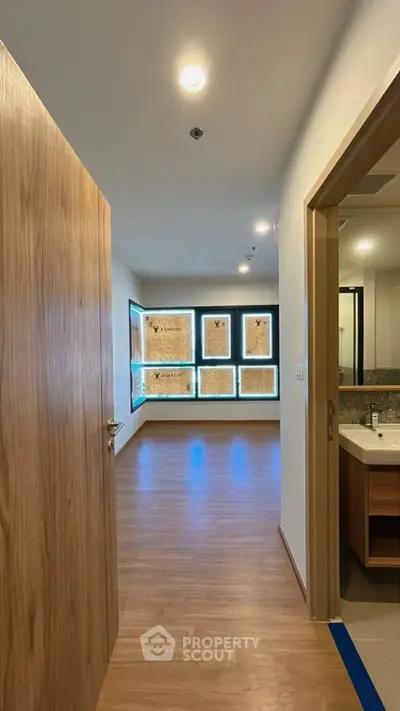 Modern apartment interior with wooden flooring and bathroom view