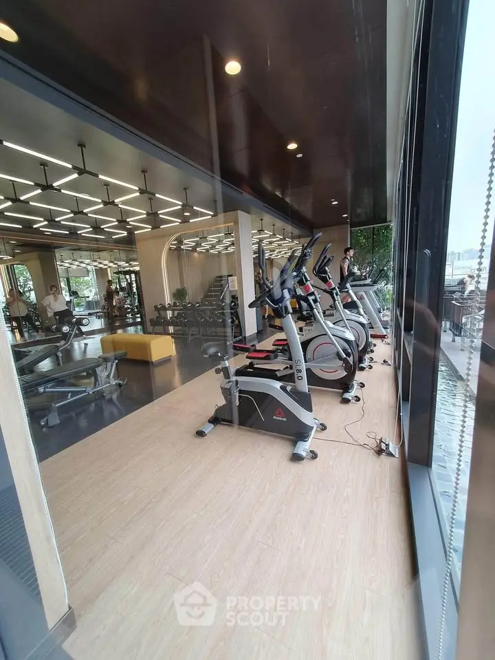 Modern gym with exercise bikes and large windows offering a scenic view, perfect for fitness enthusiasts.