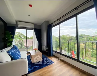 Bright living room with large windows and scenic view, modern decor and cozy ambiance.