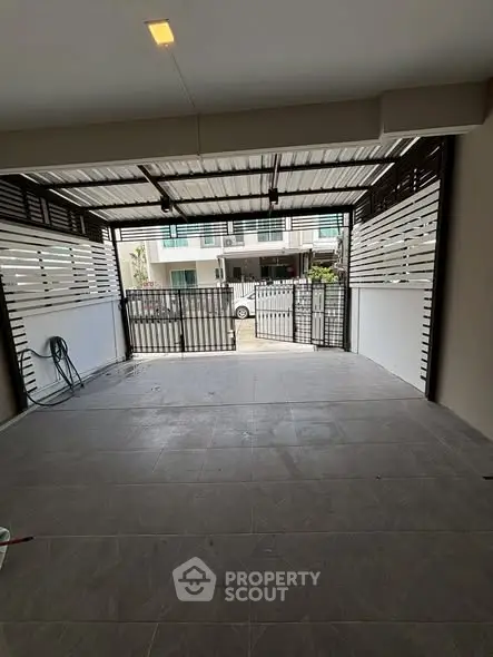 Spacious covered parking area with modern design and secure gate access.