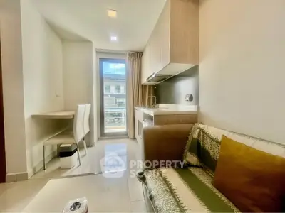 Modern apartment interior with cozy living area and compact kitchen, featuring sleek design and natural light.