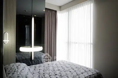 Modern bedroom with large window and stylish lighting in a contemporary apartment.