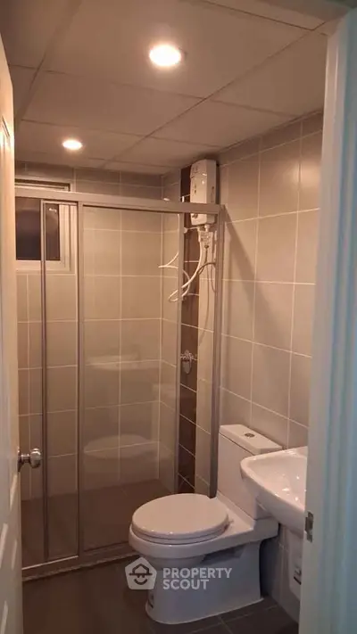 Modern bathroom with shower enclosure and sleek fixtures in a contemporary apartment.