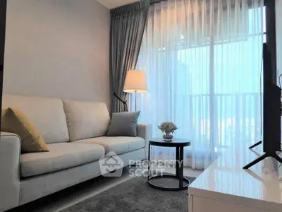 Modern living room with cozy sofa and elegant decor, featuring floor-to-ceiling windows and abundant natural light.