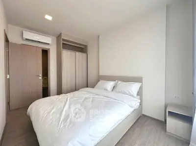 Modern bedroom with minimalist design and cozy ambiance, featuring a comfortable bed and built-in wardrobe.