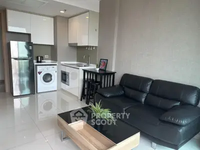 Modern open-layout kitchen and living room with sleek appliances and stylish furniture.