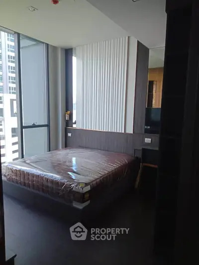 Modern bedroom with large windows and sleek design in a high-rise apartment.