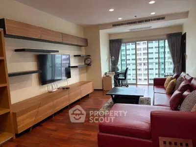 Spacious modern living room with red leather sofa and city view