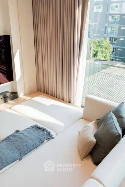 Modern living room with large windows and cozy white sofa