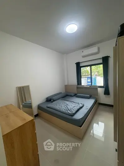 Modern bedroom with sleek design, featuring a comfortable bed, stylish dresser, and ample natural light.