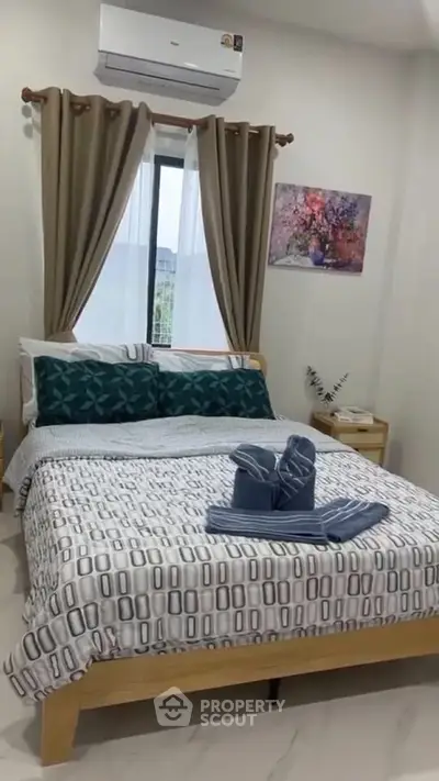 Cozy bedroom with stylish decor and air conditioning, perfect for relaxation.
