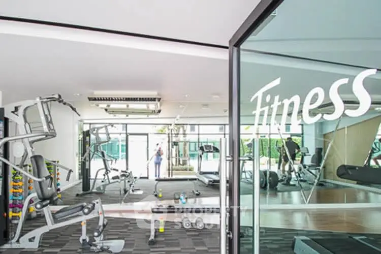 Modern fitness center with state-of-the-art gym equipment and bright natural lighting.