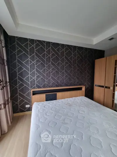Modern bedroom with stylish geometric wallpaper and wooden furniture