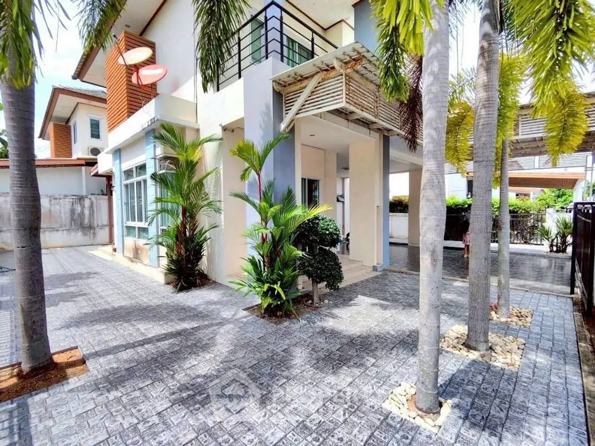 Modern two-story house with palm trees and spacious driveway