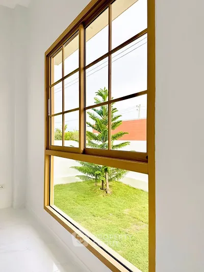 Bright window view of lush green garden from modern interior space.