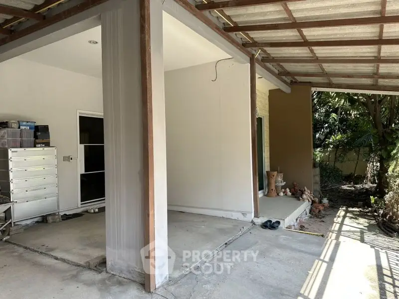 Spacious covered patio with storage area and garden view
