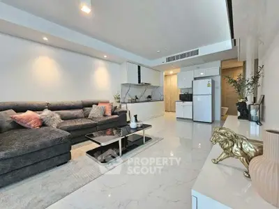 Modern living room with sleek design, spacious layout, and stylish decor, featuring a cozy sectional sofa and open kitchen.