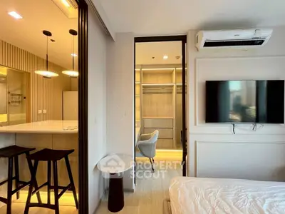 Modern apartment interior with open kitchen and cozy living area, featuring stylish furniture and ambient lighting.