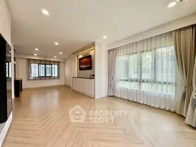 Spacious modern living room with large windows and elegant flooring