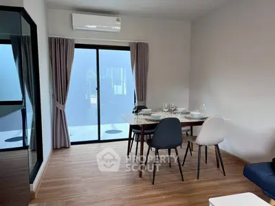 Modern dining area with elegant table setting and natural light from large window.