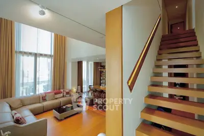 Luxurious modern living room with high ceilings and elegant staircase