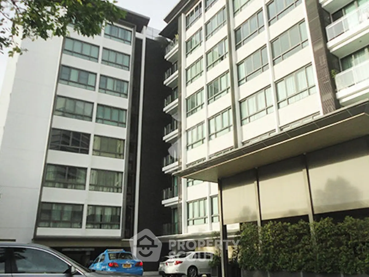 Modern urban apartment buildings with sleek design and ample parking space.