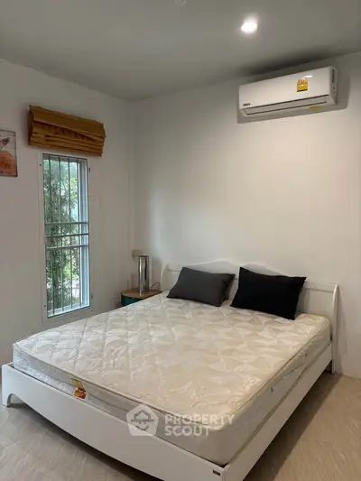 Cozy bedroom with air conditioning and natural light, perfect for relaxation and comfort.