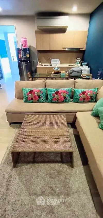 Modern living room with cozy sofa and open kitchen layout, perfect for urban living.
