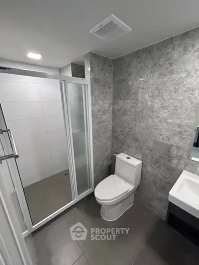 Modern bathroom with sleek shower and elegant gray tiles