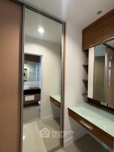 Modern bathroom with sleek wooden cabinetry and large mirror