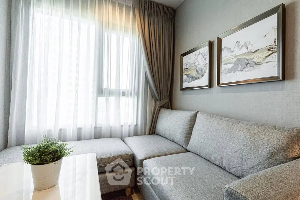 Modern living room with cozy gray sofa and elegant decor in a bright apartment.