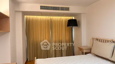 Cozy bedroom with elegant lighting and modern decor, featuring a comfortable bed and stylish floor lamp.