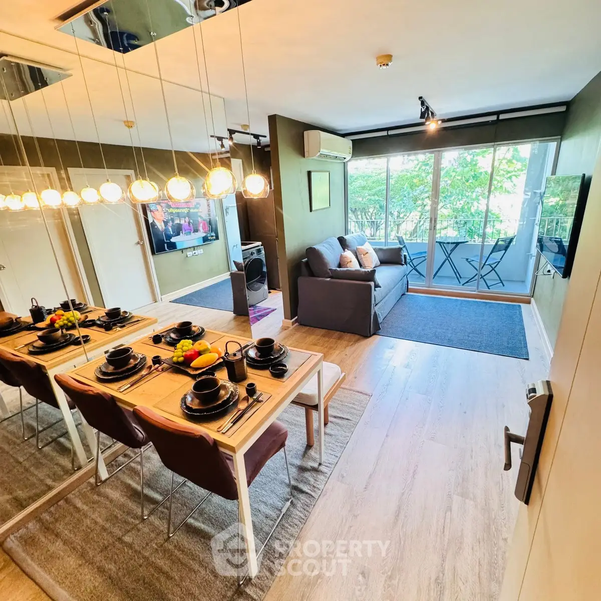 Modern living room with dining area and balcony view, featuring stylish decor and natural light.