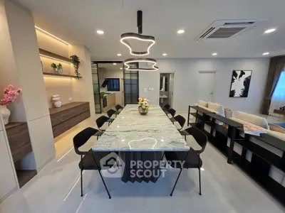 Modern open-plan living and dining area with stylish lighting and elegant decor.